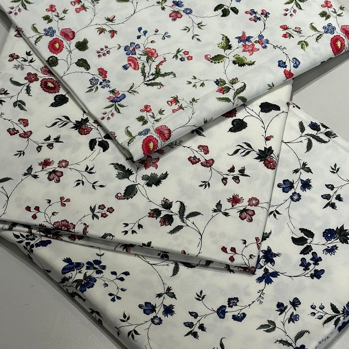 Floral patterned fabric with red, blue, and green flowers on a white background