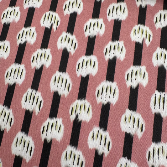 Patterned fabric with black and white stripes on a pink background