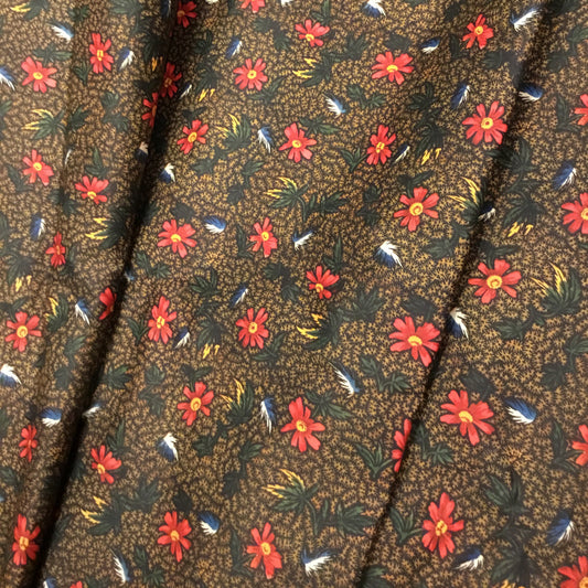 Floral patterned fabric with red flowers on a brown background