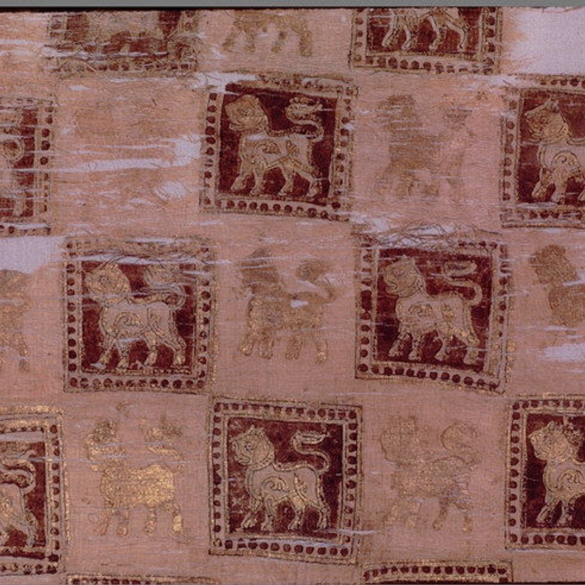 An ancient textile or papyrus fragment featuring repeated square motifs of stylized lions in dark red and gold, set against a light beige background with a white border.