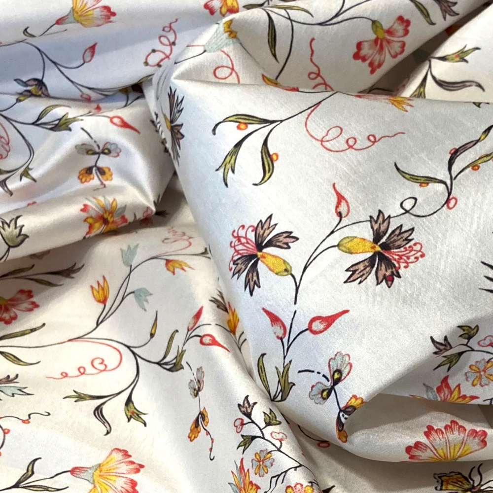 Floral patterned fabric with colorful flowers and leaves on a white background