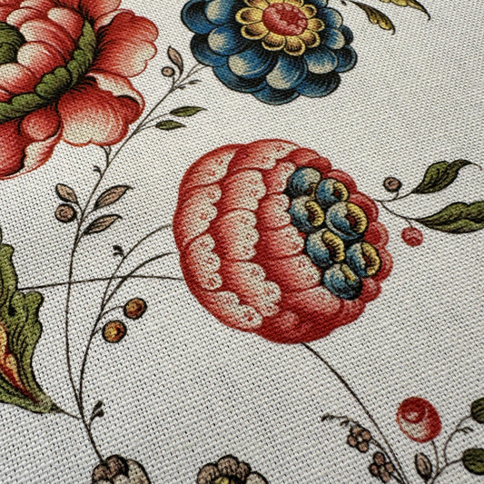 Close-up of floral fabric pattern with red, blue, and green flowers on a light background
