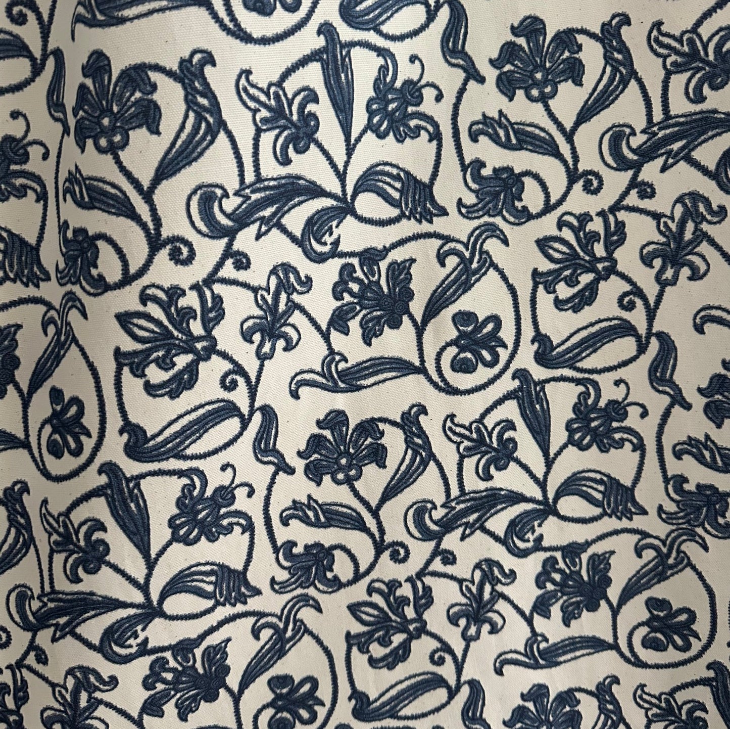 A blue floral pattern on a white background, featuring intricate scroll designs.