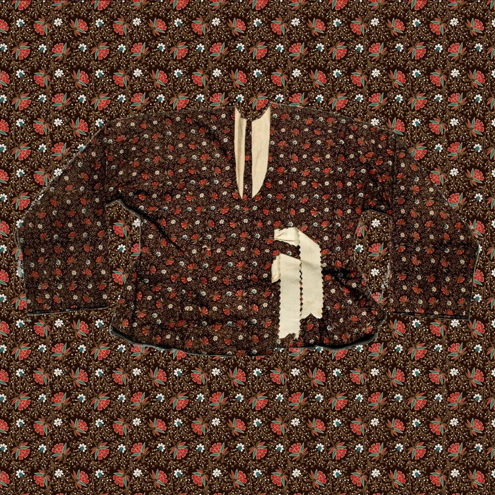 Close-up of a patterned fabric with small red and white shapes on a brown background
